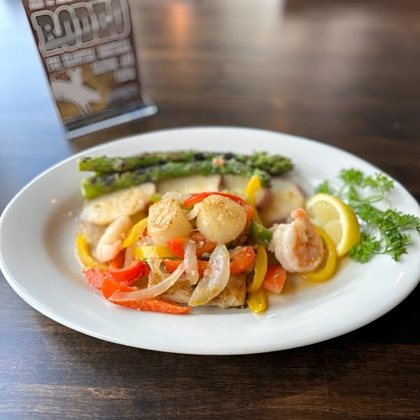 Bayou City Seafood & Pasta's seafood dish with scallops, shrimp, vegetables, and asparagus.