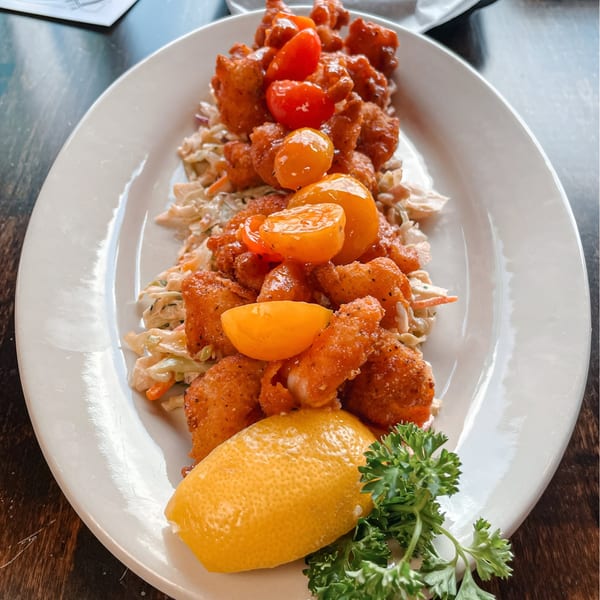 Bayou City Seafood & Pasta's fried shrimp with coleslaw, cherry tomatoes, lemon, and parsley.